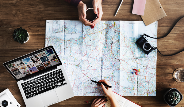 a person looking at a map on top of a wooden table